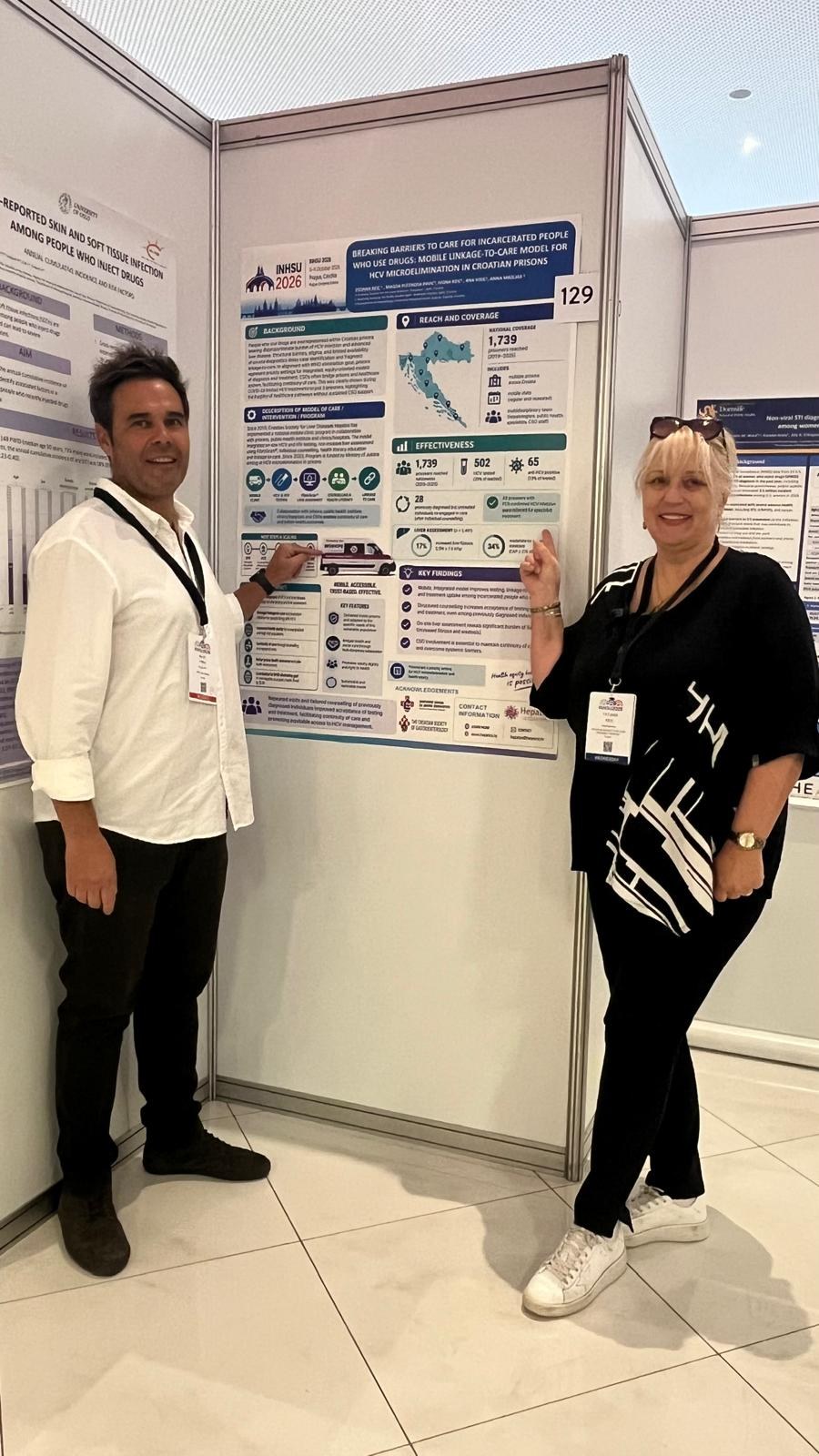 Hepatos poster on hepatitis C care in Croatian prisons with two delegates beside it
